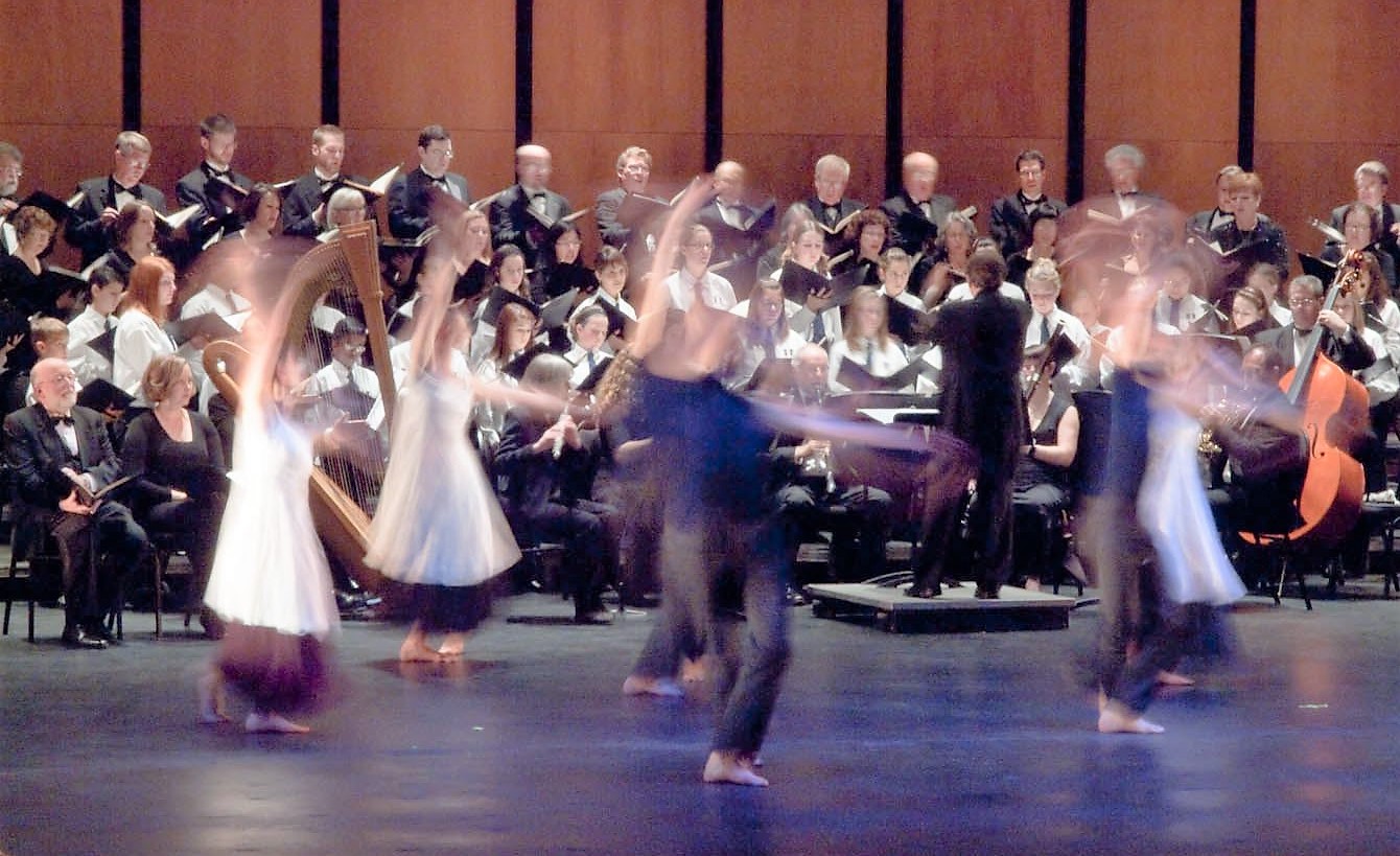 colour photo of GCC on stage with six dancers in the foreground